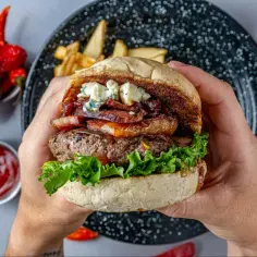 Prawdziwe burgery przepis: soczysta wołowina, chrupiący bekon, ser pleśniowy i świeża sałata w domowej bułce. Idealne na grilla!