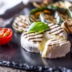 Pyszny camembert z grilla, podany z grillowanymi warzywami i pomidorkiem. Idealna przekąska na lato.