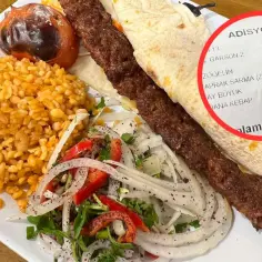 Turecki kebab z ryżem, sałatką i pieczonym pomidorem. Na rachunku widnieje nazwa "DANA KEBAP".