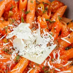 Penne z sosem pomidorowym, oliwkami i parmezanem. Idealny przepis na makaron z sosem, który zachwyci każdego.