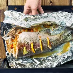 Ryba pieczona w folii aluminiowej z cytryną i ziołami.