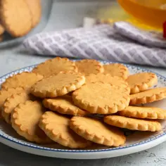 Stos ciastek na talerzu, idealny prosty przepis na ciastka. Złociste, kruche, z karbowanymi brzegami.