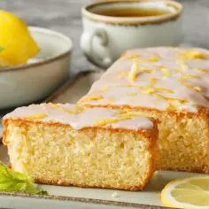 Wilgotna babka cytrynowa z lukrem i skórką cytrynową, udekorowana miętą.