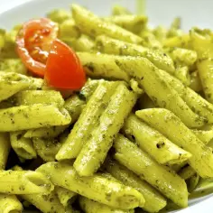 Makaron penne z sosem pesto i pomidorkiem koktajlowym.