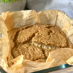 Upieczony chleb keto w papierze do pieczenia w szklanej formie.