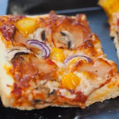 Domowa pizza na blachę z pieczarkami, cebulą i pomidorkami. Idealny przepis na szybki obiad.