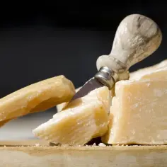 Kawałki twardego sera, nóż do sera. Czy parmezan można zastąpić Grana Padano?
