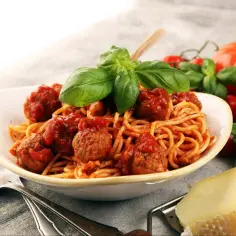 Pyszne spaghetti z klopsikami w sosie pomidorowym, świeża bazylia i parmezan. Idealne przyprawy do spaghetti to podstawa!