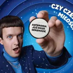 Michał Sikorski z zaskoczoną miną trzyma ciastko Oreo z napisem "Asteroida już pisze serenadę". Czy czeka go miłość?