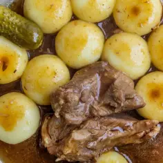 Jak podgrzać kluski śląskie? Zobacz, jak pysznie wyglądają z gulaszem i ogórkami kiszonymi.