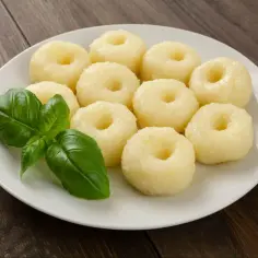 Talerz z dziesięcioma kluskami śląskimi i gałązką bazylii. Ile klusek śląskich na osobę? To zależy od apetytu!