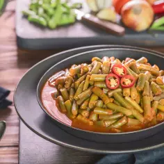 Fasolka szparagowa w sosie pomidorowym z plasterkami chili na wierzchu.