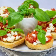 Bruschetta z pomidorami i mozzarellą, świeża bazylia i chrupiące pieczywo. Idealny przepis na letnią przekąskę.
