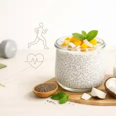 Zdrowy deser z chia z jogurtem, mango i kokosem. Obok leżą hantle i mata do ćwiczeń, symbolizujące aktywny tryb życia.