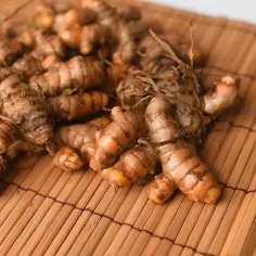 Kłącza kurkumy, przyprawy kluczowej dla smaku curry, leżą na bambusowej macie.
