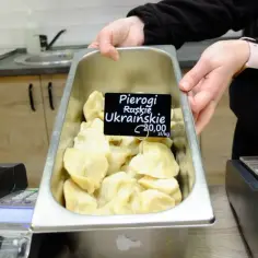 Taca pełna pysznych pierogów ukraińskich, gotowych do sprzedaży. Cena 20,00 zł/kg.