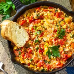 Menemen - jajecznica z pomidorami, papryką i cebulą w żeliwnej patelni, z pieczywem.