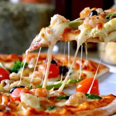 Rozciągający się ser z kawałka pizzy, z krewetkami, pomidorkami i oliwkami. Idealne ciasto na pizzę.