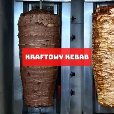 Dwa pionowe, obracające się rożny z mięsem na kebab. Jeden ciemniejszy, drugi jaśniejszy. Napis "KRAFTOWY KEBAB" na czerwonym tle.