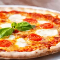 Pyszna pizza włoska z pomidorkami, mozzarellą i bazylią. Idealny przepis na klasyczną Margheritę.