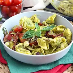 Pyszne tortellini z serem w sosie pesto, z pomidorkami i bazylią. Idealne danie, by pokazać, z czym podawać tortellini z serem.