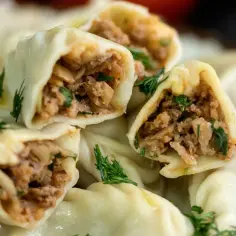 Pyszne pierogi z domowym farszem na pierogi z mięsem mielonym, ozdobione świeżym koperkiem.