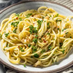 Pyszne danie z makaronem spaghetti, posypane natką pietruszki i płatkami chili. Idealne na szybki obiad.