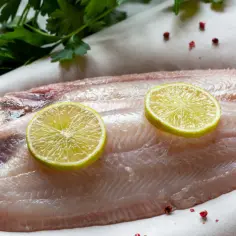Surowa sola z plasterkami limonki i natką pietruszki.