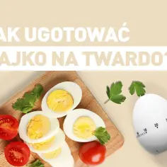 Jajka na twardo, pomidorki i minutnik kuchenny w kształcie jajka.