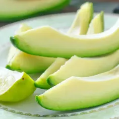 Pokrojone awokado i ćwiartka limonki na talerzu.