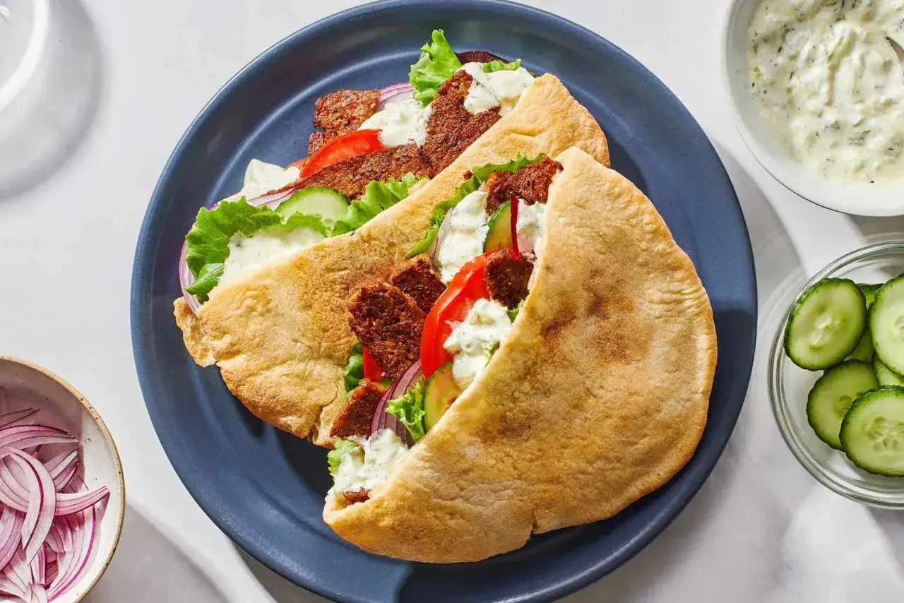 Dwa sycące kebab w picie z soczystym mięsem, świeżymi warzywami i kremowym sosem.