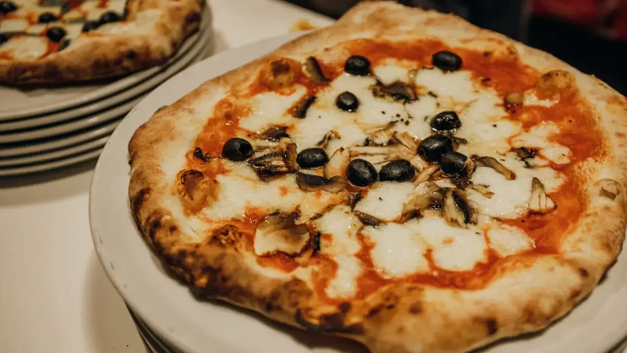 Pyszna pizza włoska z oliwkami i grzybami, idealna na wieczór. Ten przepis na pizzę włoską jest prosty i szybki.