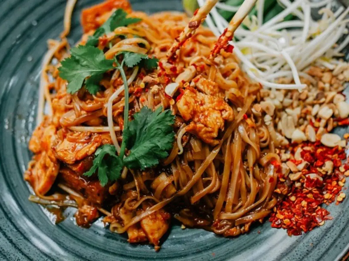 Pyszne pad thai co to? Makaron ryżowy z kurczakiem, kiełkami, orzeszkami i płatkami chili.