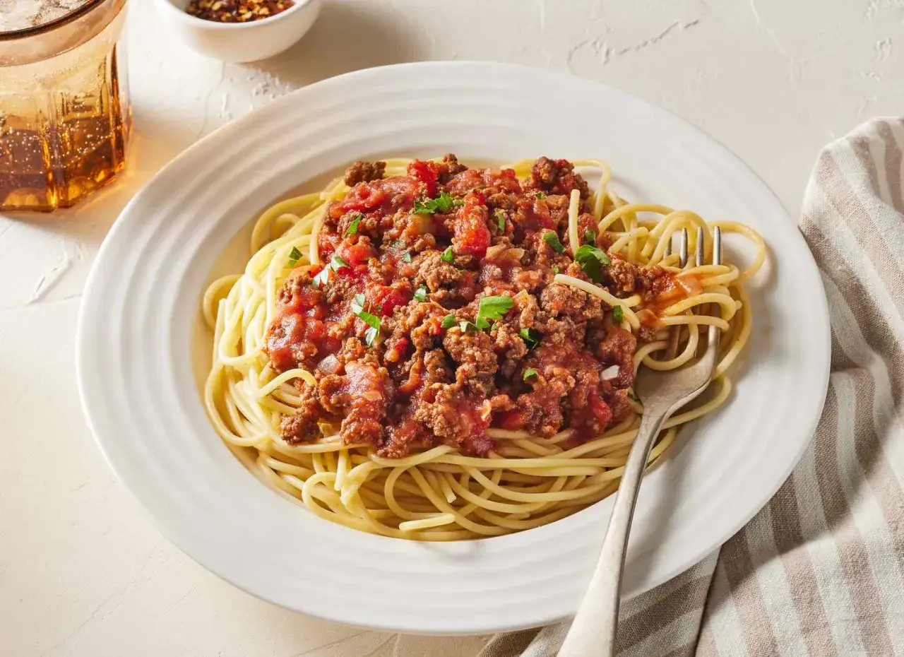 Prosty przepis na spaghetti z mięsem mielonym. Aromatyczny sos boloński na złocistym makaronie, posypany natką pietruszki. Idealny na szybki obiad.
