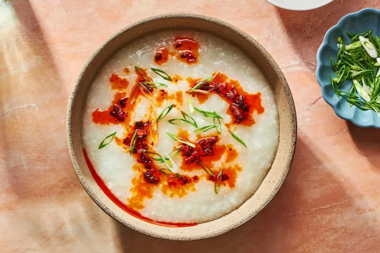 Miseczka z aromatycznym congee, polana ostrym olejem chili i posypana szczypiorkiem.
