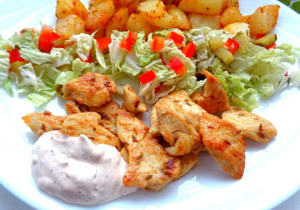 Pyszna shoarma drobiowa z pieczonymi ziemniakami, sałatką z papryką i sosem.