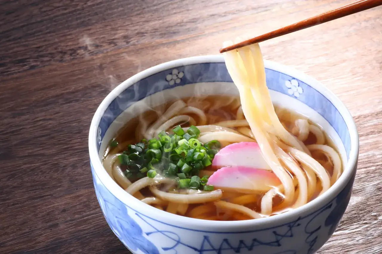 Gorący makaron udon z bulionem, szczypiorkiem i rybnymi kluseczkami. Idealny przepis na udon.
