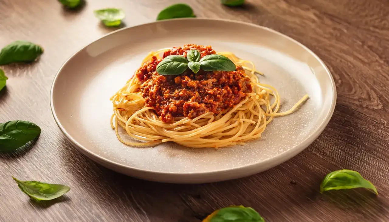 Pyszne spaghetti bolognese, idealne na prosty przepis. Aromatyczny sos mięsny z bazylią na złocistym makaronie.