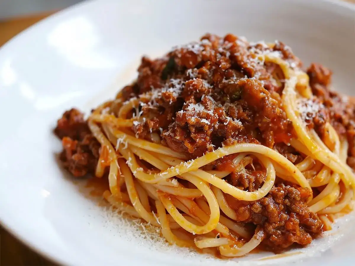 Pyszne spaghetti bolognese, idealne na prosty obiad. Makaron z bogatym sosem mięsnym, posypany parmezanem.