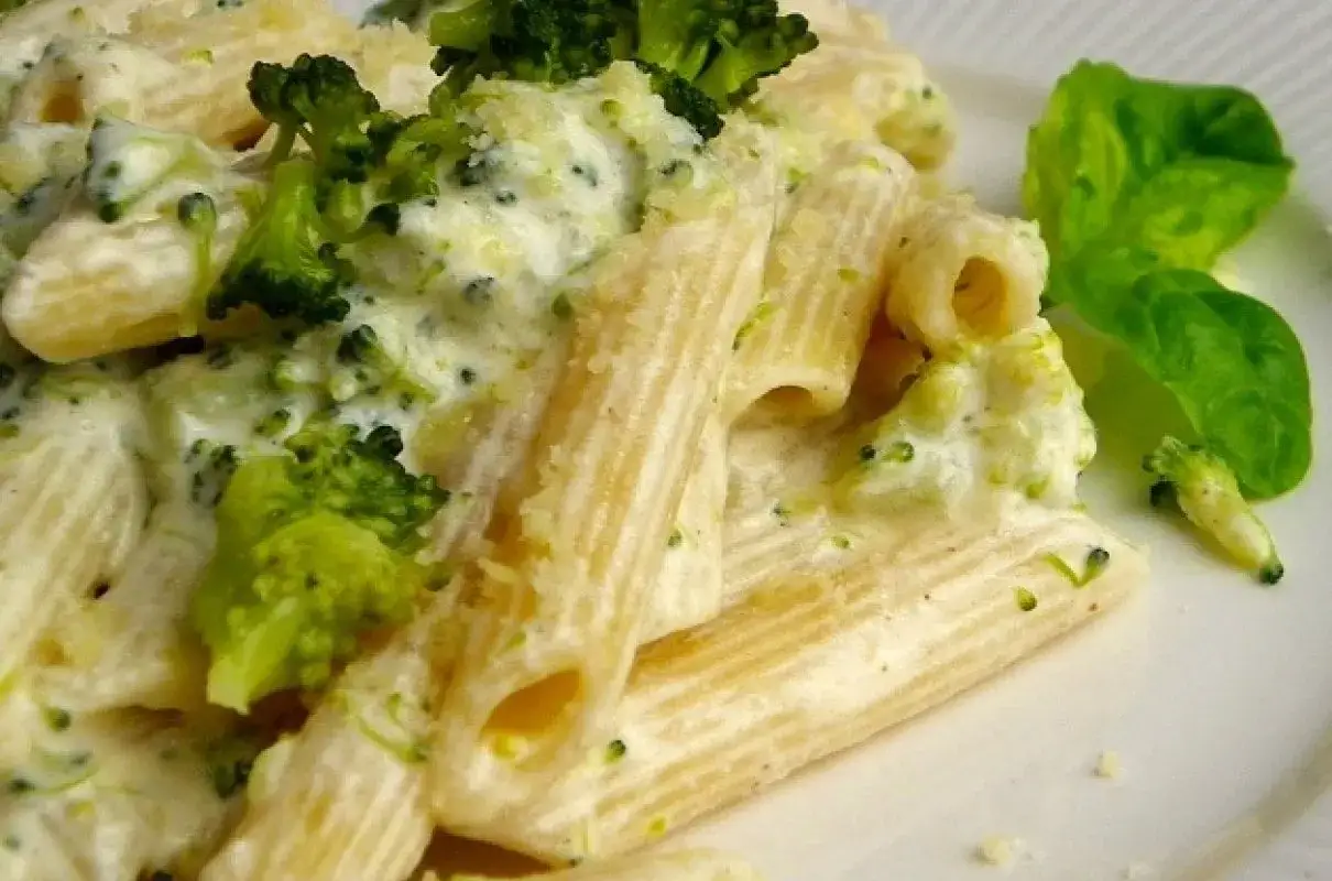 Penne z brokułami w kremowym sosie śmietanowym, posypane parmezanem. Pyszne danie, które zachwyci każdego.