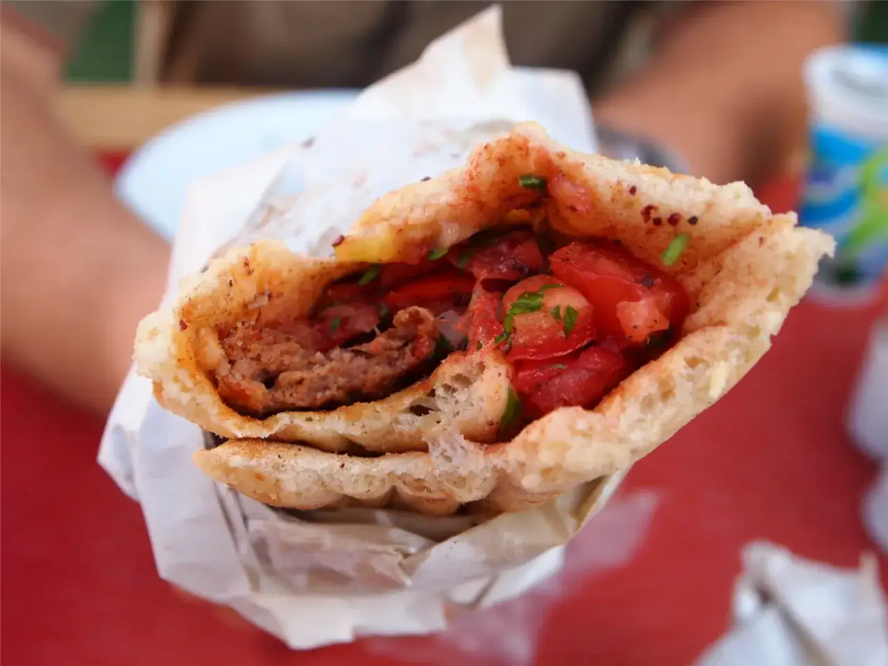 Pyszny turecki kebab z soczystym mięsem, pomidorami i ziołami, zawinięty w chrupiące pieczywo.