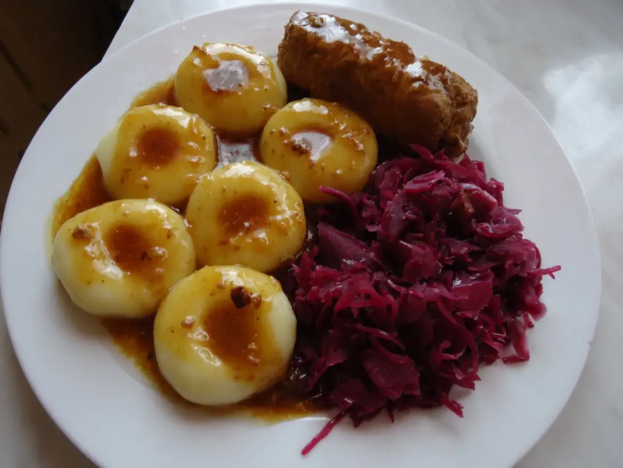 Śląskie kluski śląskie z sosem, kiełbasa i surówka z czerwonej kapusty. Pyszny kapusta czerwona przepis po śląsku.