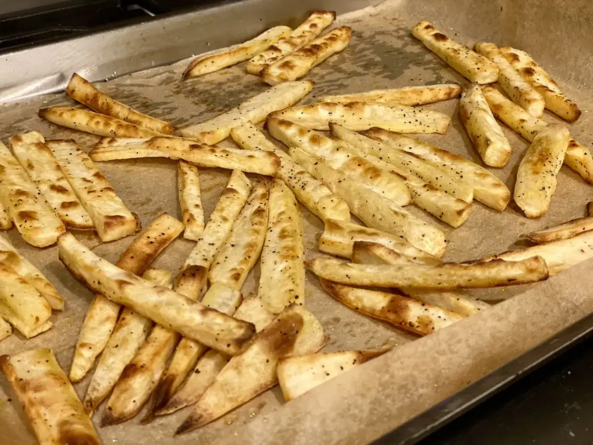 Chrupiące frytki z batata, lekko przypieczone i doprawione pieprzem, gotowe do podania.