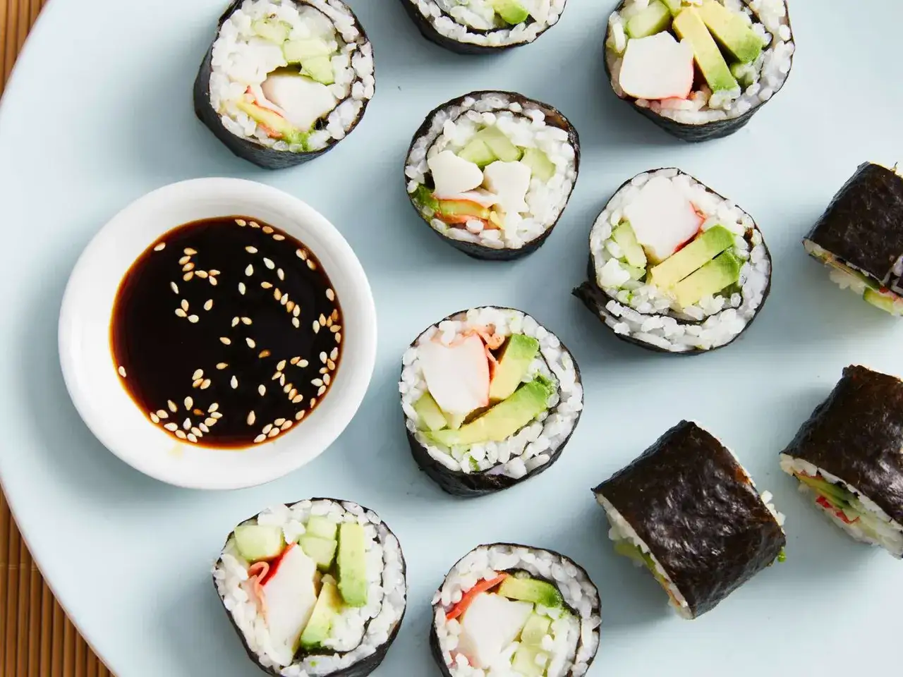 Rolki sushi z awokado, ogórkiem i paluszkami krabowymi, gotowe do zanurzenia w sosie sojowym. Idealne, by zacząć przygodę, jak zrobić sushi!