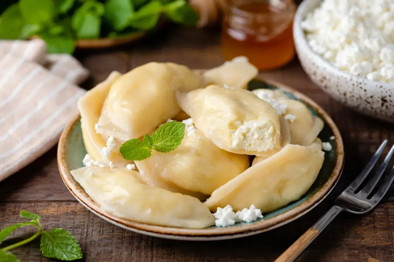 Pyszne pierogi z serem, jak u babci. Delikatne ciasto i kremowe nadzienie. Idealne na deser lub obiad.