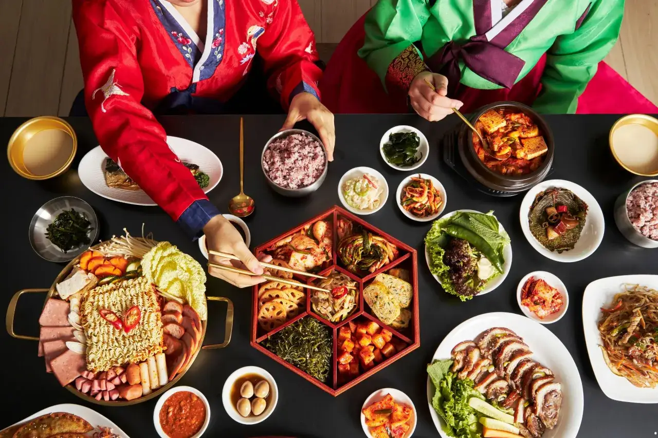Koreańska uczta: kimchi co to? Różnorodne dania, w tym zupa z tofu, makaron, mięso i oczywiście kimchi w wielu odsłonach.