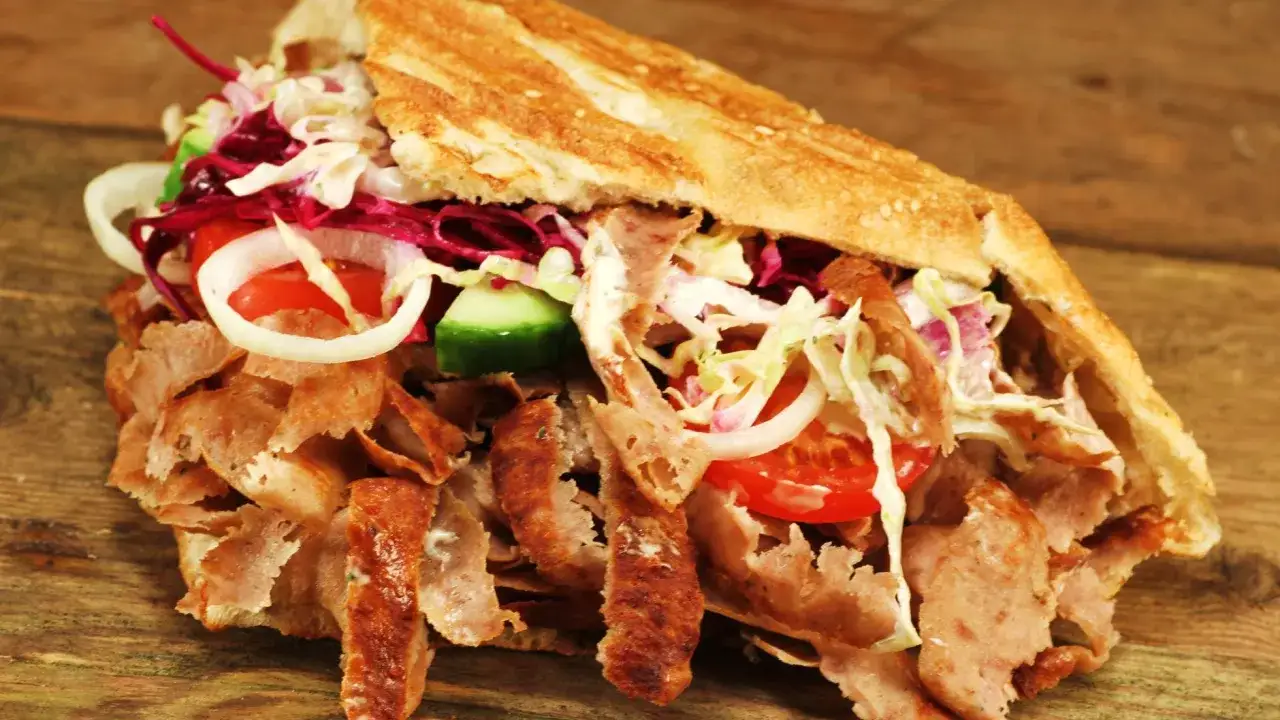 Apetyczny kebab z mięsem, warzywami i sosem. Czy kebab jest zdrowy? Zależy od składników i sposobu przygotowania.