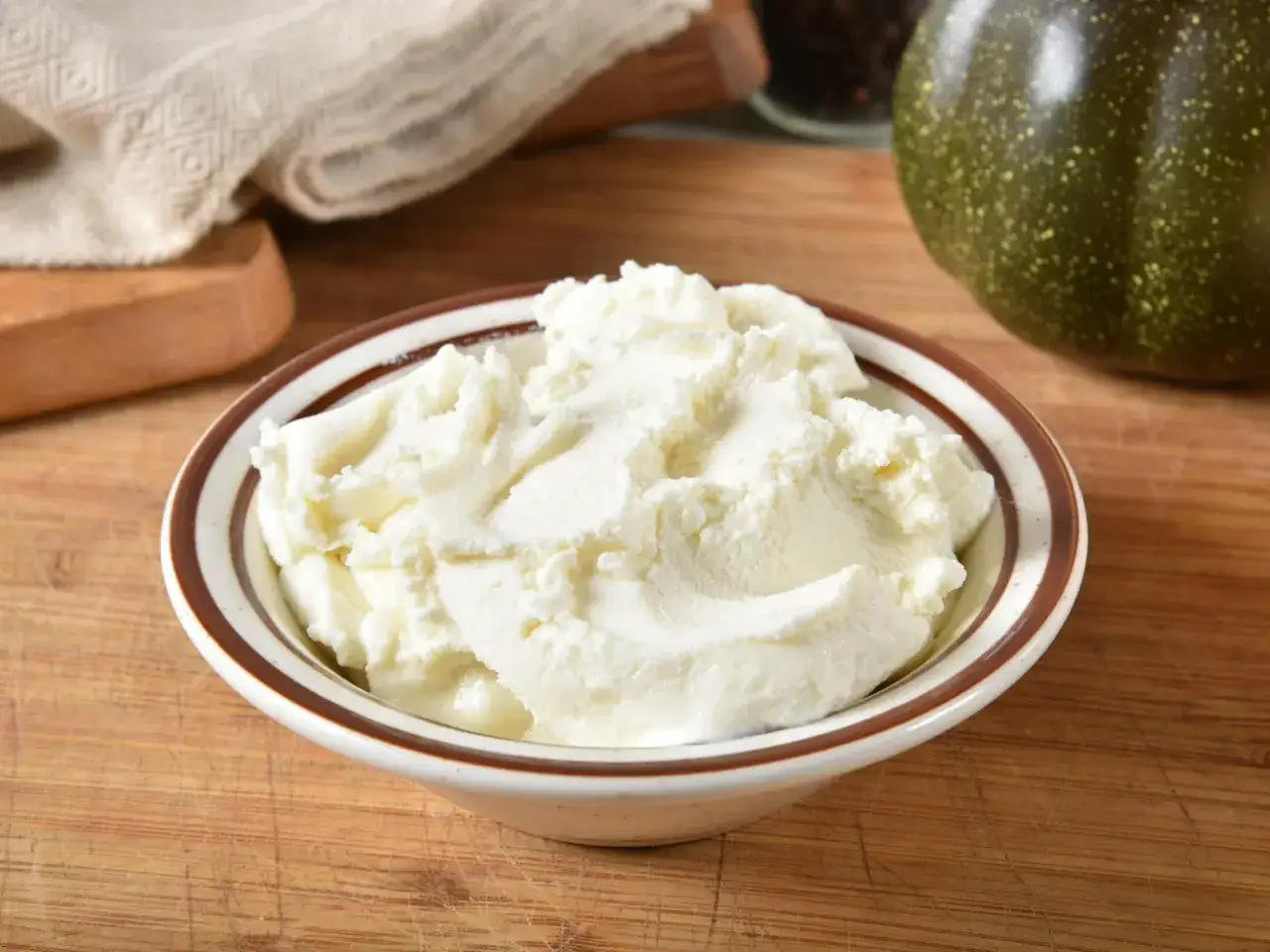 Kremowy serek ricotta w miseczce, gotowy do przygotowania pysznych deserów lub dań wytrawnych.