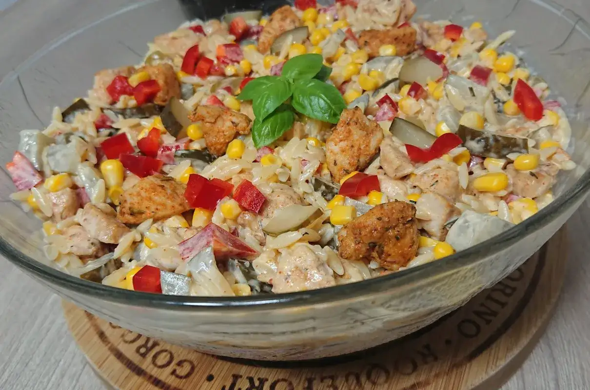 Pyszna sałatka gyros z makaronem orzo, kurczakiem, kukurydzą, papryką i ogórkiem kiszonym. Idealna na obiad lub kolację.