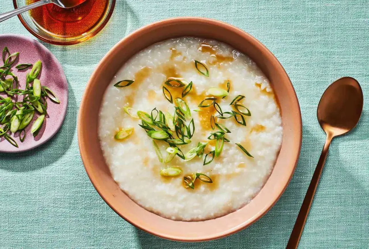 Miseczka pysznego congee z zieloną cebulką i sosem. Idealne na śniadanie.